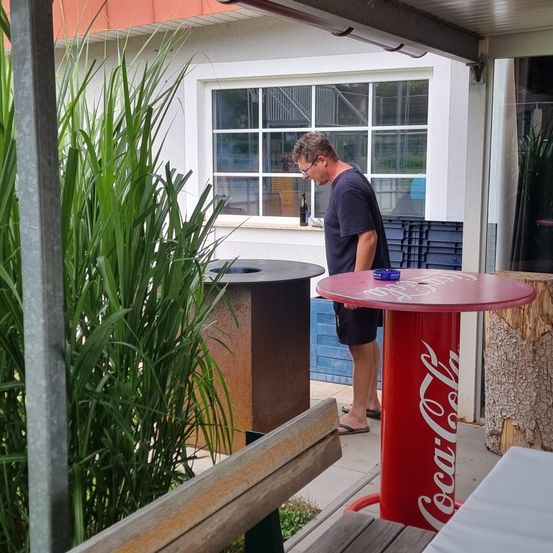 Bild enthält, Interior Design, Adult, Male, Man, Person, Table, Shelter, Potted Plant, Wood, Crowd
