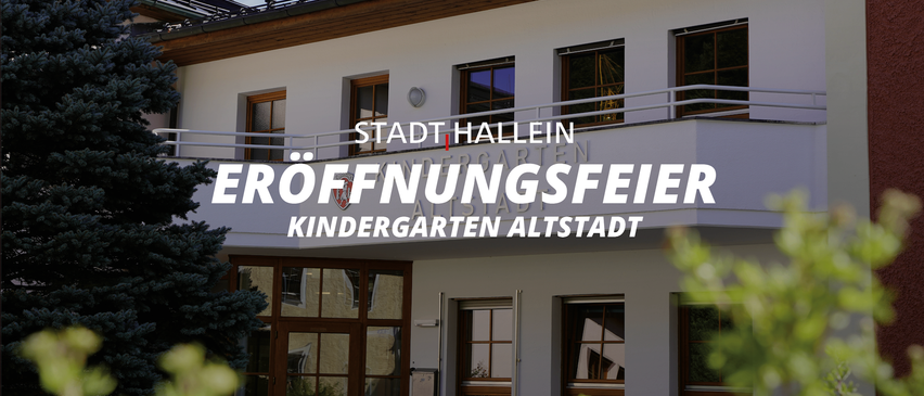 Ein weißes Gebäude mit mehreren Fenstern und einem Balkon zeigt ein Schild mit der Aufschrift 'Stadt Hallein'. Darunter sind die Worte 'Öffnungsfeier Kindergarten Altstadt' prominent angebracht.