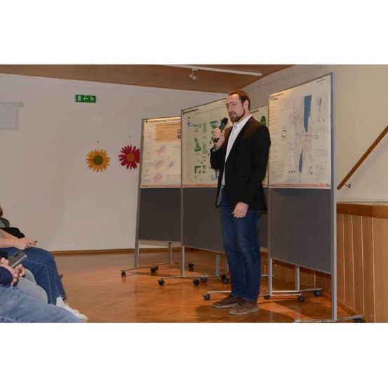 Bild enthält, Furniture, Table, Desk, Adult, Male, Man, Person, White Board, Interior Design, Pants