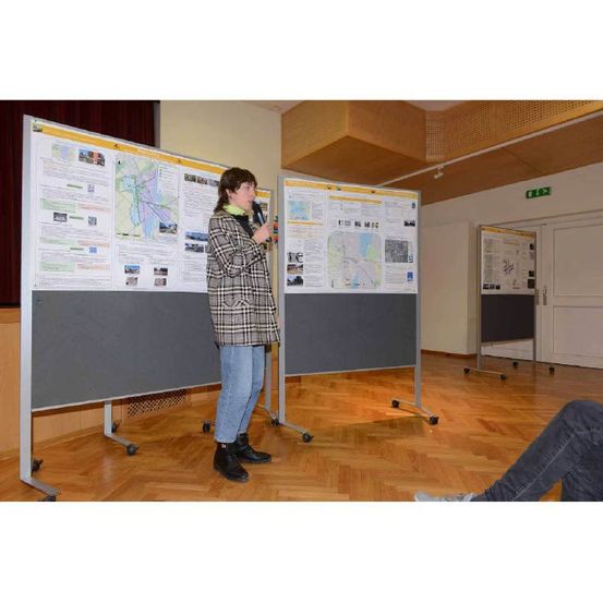 Bild enthält, Desk, Furniture, Table, White Board, Person, Indoors, Interior Design, Footwear, Shoe, Face