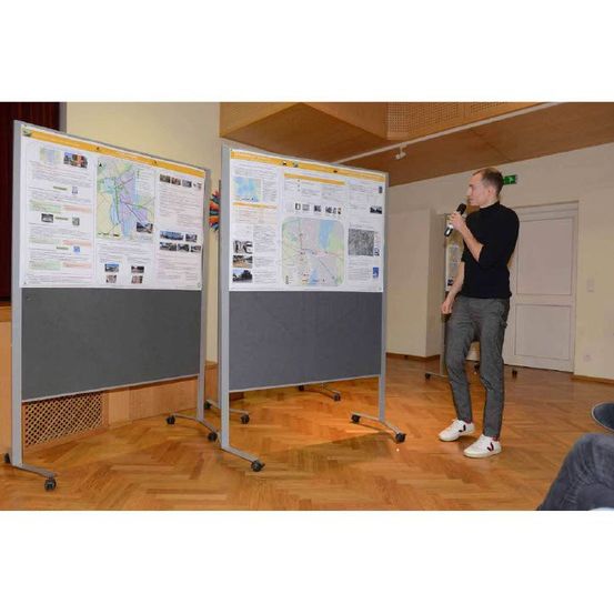 Bild enthält, Furniture, Table, Desk, White Board, Screen, Flooring, Interior Design, Adult, Man, Person