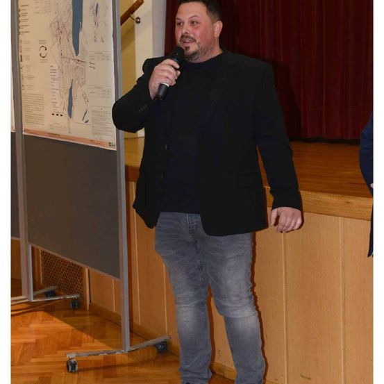 Bild enthält, Microphone, Crowd, Person, Wood, Pants, Adult, Male, Man, Jeans, Coat