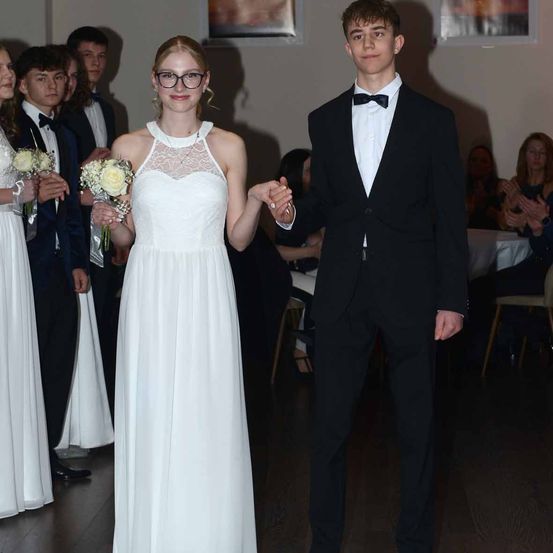 Bild enthält, Formal Wear, Suit, Tuxedo, Dress, Blazer, Coat, Jacket, Portrait, Gown, Wedding Gown