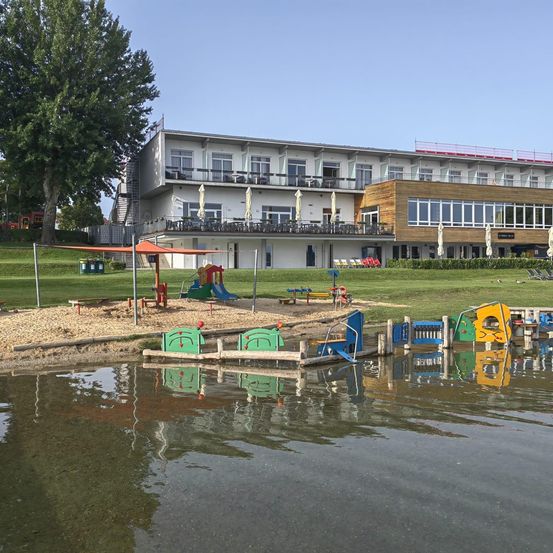 Bild enthält, Nature, Outdoors, Scenery, Building, Waterfront, Lakefront, Shelter, City, Grass, Play Area