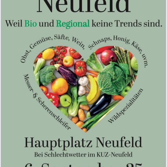 Die Werbung zeigt eine Vielfalt an frischem Obst und Gemüse in Herzform, die lokale und biologische Produkte fördern. Es werden Früchte, Gemüse und andere Artikel wie Käse und Honig hervorgehoben. Der Text lautet: 'Hauptplatz Neufeld Bei Schlechtwetter im KUZ-Neufeld.' Es ist ein grüner Hintergrund mit einem fettgedruckten Titel.