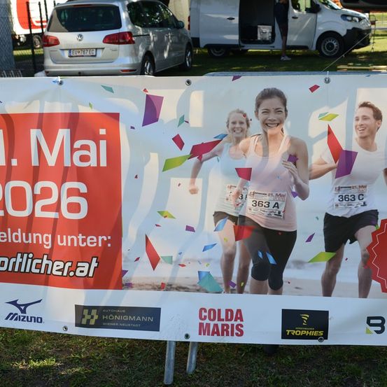 Ein Werbebanner für einen Laufwettbewerb am 1. Mai 2026 mit drei Läufern und einer Registrierungswebsite.