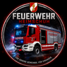 A red fire truck with lights on, labeled 'Feuerwehr Heimschuh', drives on a wet road, surrounded by a circle with the same text and the community's motto.