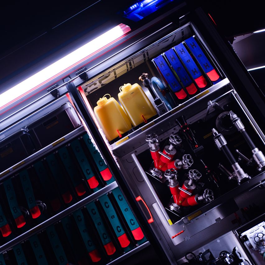 Nahaufnahme des Ausrüstungslagers eines Feuerwehrmanns, beleuchtet. Enthält Feuerlöscher, Werkzeuge und Flaschen, auf mehreren Regalen angeordnet.