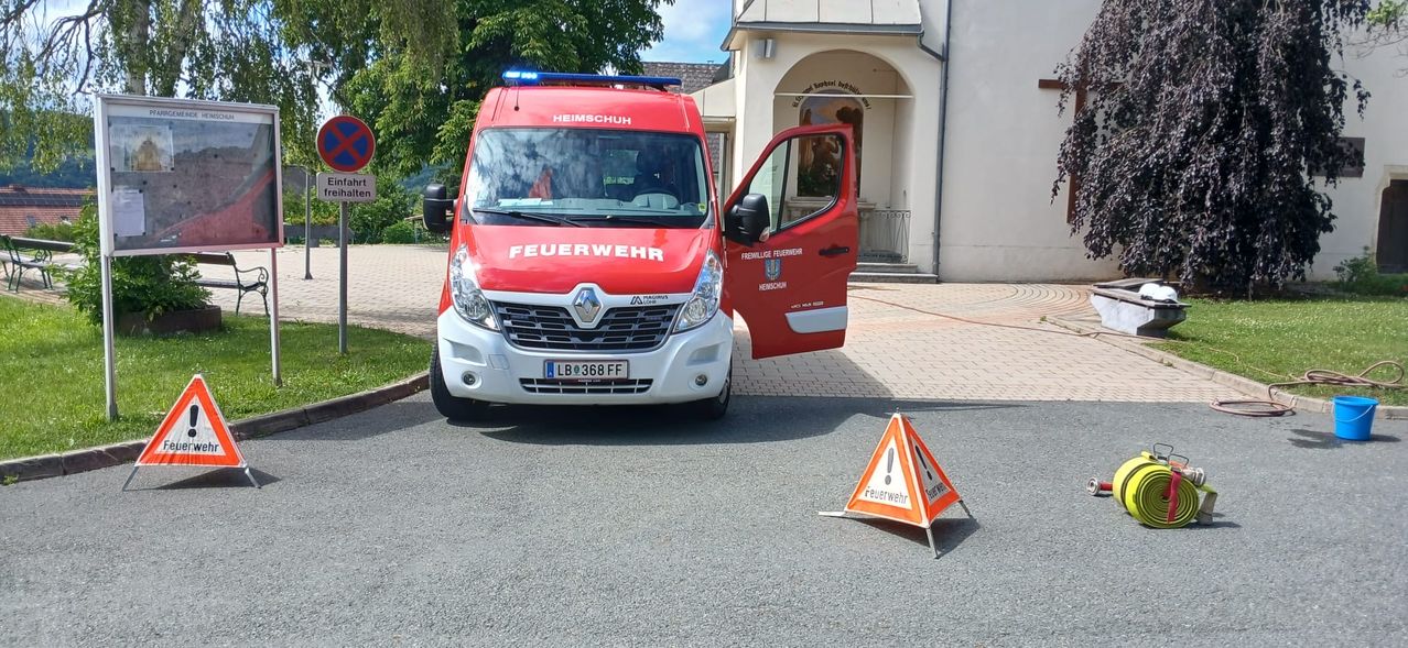 Ein roter Feuerwehrwagen mit offener Tür ist vor einem Gebäude geparkt. Es hat den Text Heimsuch und Feuerwehr an der Seite und ein Kennzeichen, das LB 368 FF lautet.