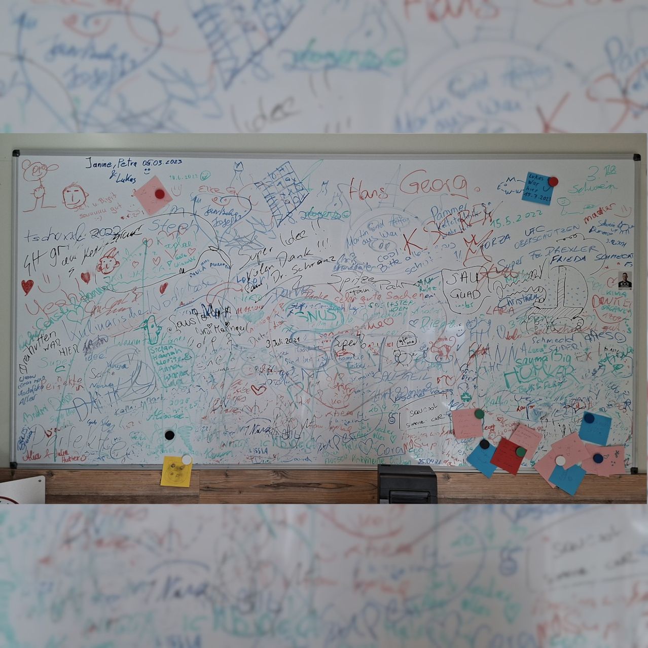 Ein Whiteboard, das mit farbenfrohen Zeichnungen, Unterschriften und Notizen bedeckt ist, mit einigen Haftnotizen befestigt. Das Board ist mit verschiedenen Doodles, Texten und Symbolen gefüllt.