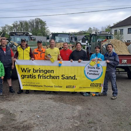 Bild enthält, Soil, Neighborhood, Person, Banner, Jeans, Worker, Wheel, Outdoors, Truck, People