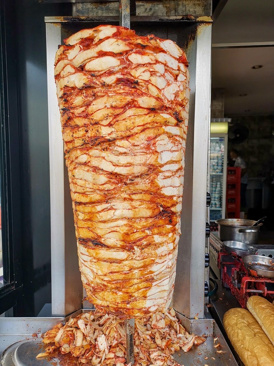 Ein Nahaufnahme eines großen Fleischgerichts, das in einer kommerziellen Küche zubereitet wird, mit roter Sauce und Gewürzen gekrönt.
