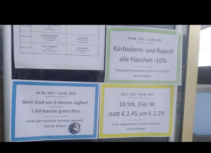 Plakate an einer Glastür werben für Rabatte auf verschiedene Artikel. Ein Plakat bietet 10% Rabatt auf alle Flaschen. Ein weiteres Plakat bewirbt eine kostenlose Milchflasche beim Kauf von 6 kleinen Joghurts. Ein weiteres Plakat bewirbt Eier zu einem reduzierten Preis.