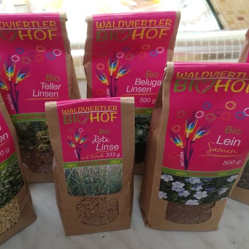 Mehrere Tüten mit Bio-Samen von Waldviertel Bio Hof sind ausgestellt. Dazu gehören Bio Teller Linsen, Bio Beluga Linsen, Bio Rote Linse und Bio Lein Samen, jeweils 500 Gramm.