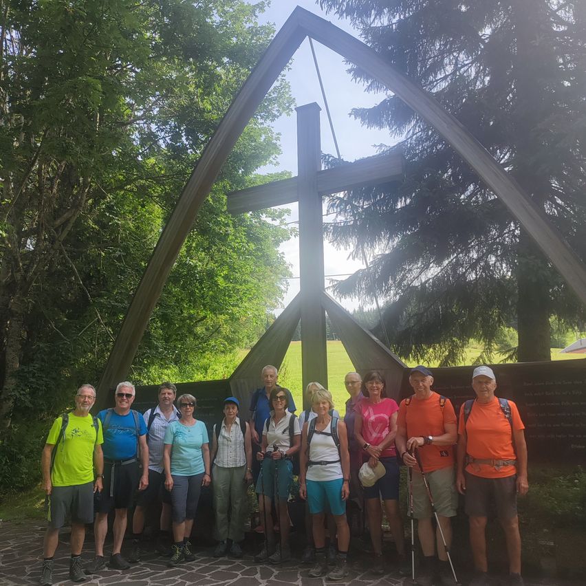 Wandergruppe vor einem Holzkreuz in der Steiermark