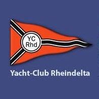 Ein orangefarbener Wimpel zeigt 'YC Rhd' in einem weißen Kreis mit schwarzen Streifen auf blauem Hintergrund. Darunter steht 'Yacht-Club Rheindelta.'