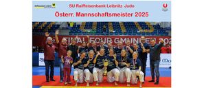 Das Plakat für den SU Raiffeisenbank Leibnitz Judo Osterreich Mannschaftsmeister 2025. Eine Gruppe von Menschen, einschließlich Kindern, posiert für ein Foto. Sie tragen Judo-Uniformen und halten Pokale. Dahinter befindet sich ein Stadion mit roten und gelben Sitzen.