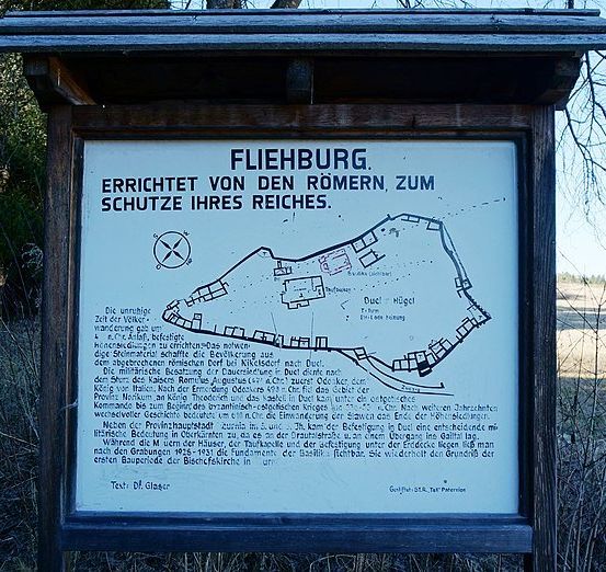 Ein Schild zeigt eine Karte von Fliehburg, erbaut von den Römern zum Schutz ihres Reiches. Die Karte zeigt eine burgartige Struktur mit Befestigungen und Türmen.