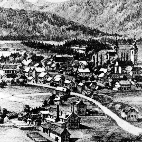 Eine alte Schwarz-Weiß-Zeichnung zeigt eine Stadt in einem Tal, umgeben von Bäumen und Bergen, mit Gebäuden, einer Kirche und einem Fluss sichtbar.