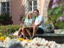 Bild enthält, Potted Plant, Bench, Person, Sitting, Planter, Adult, Female, Woman, Male, Man