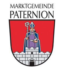 Das Logo der Marktgemeinde Paternion zeigt einen Schild mit einem Bischof, der einen Stab und ein Buch hält und auf einem Burgturm mit einem Tor steht.