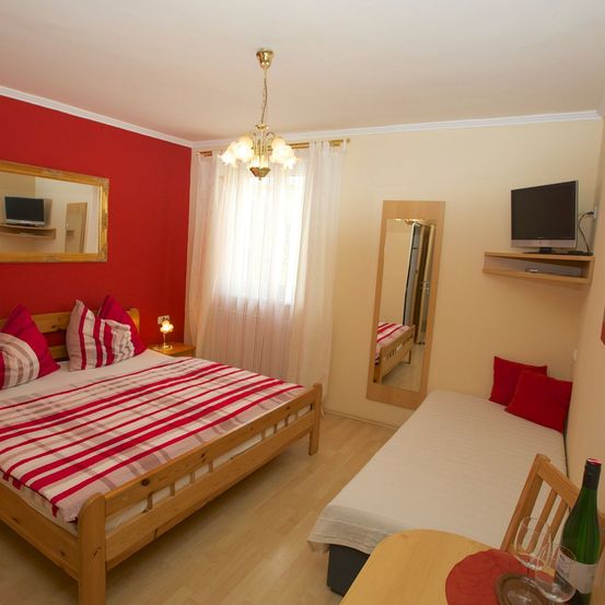 Bild enthält, Computer Hardware, Hardware, Monitor, Screen, Corner, Interior Design, TV, Furniture, Living Room, Bed