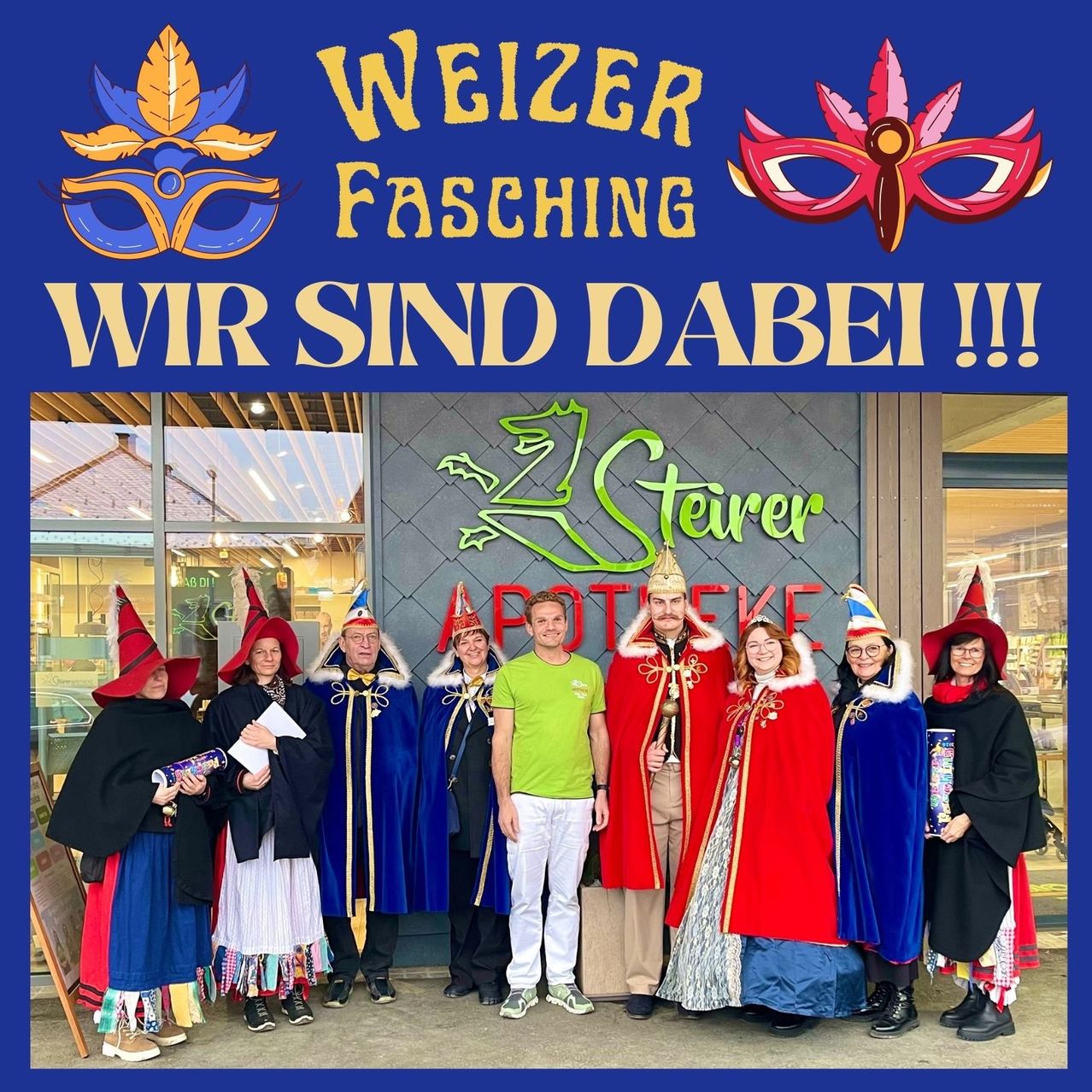 Eine Gruppe von Menschen in bunten Kostümen und Hüten steht vor einem Gebäude mit einem Schild, das 'Weizer Fasching Wir Sind Dabei !!!' besagt. Einige halten Requisiten. Im Hintergrund sind ein Glasfenster und ein maskiertes Schild zu sehen.