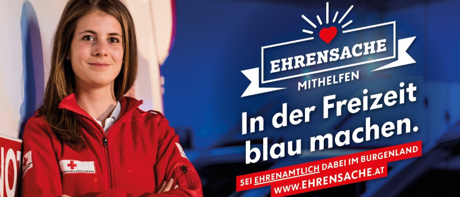 Eine lächelnde Frau in einem roten Jackett steht vor einem blauen Hintergrund mit einem roten Herz und dem Text 'EHRENSACHE MITHELFEN In der Freizeit blau machen.' und einer Website-URL.