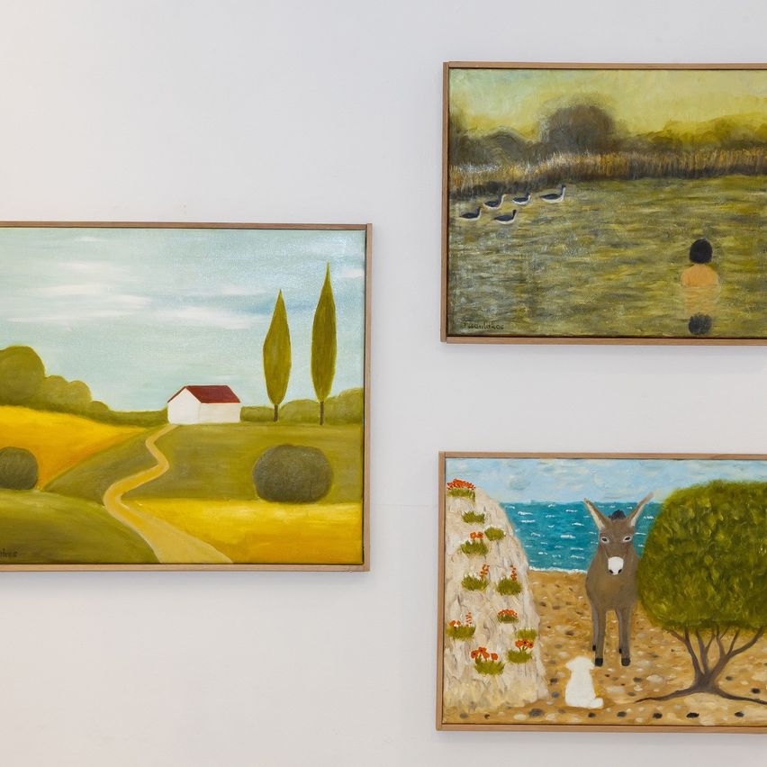 Drei Gemälde sind an einer weißen Wand aufgehängt. Das linke Gemälde zeigt eine ländliche Landschaft mit einem Haus und einem schmalen Pfad. Das mittlere Gemälde zeigt eine Gruppe von Enten in einem sumpfigen Feld. Das rechte Gemälde zeigt einen Esel und einen weißen Hund in der Nähe des Meeres mit einem Baum.