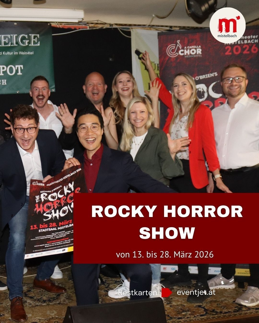 Eine Gruppe von Menschen posiert für ein Foto, einige lächeln, vor einem Banner mit dem Text 'ROCKY HORROR SHOW'. Sie halten ein Plakat für dasselbe Event. Der Text auf dem Plakat lautet '13. bis 28. März'. Das Bild enthält auch ein Banner mit den Worten 'mistelbach 2026'.