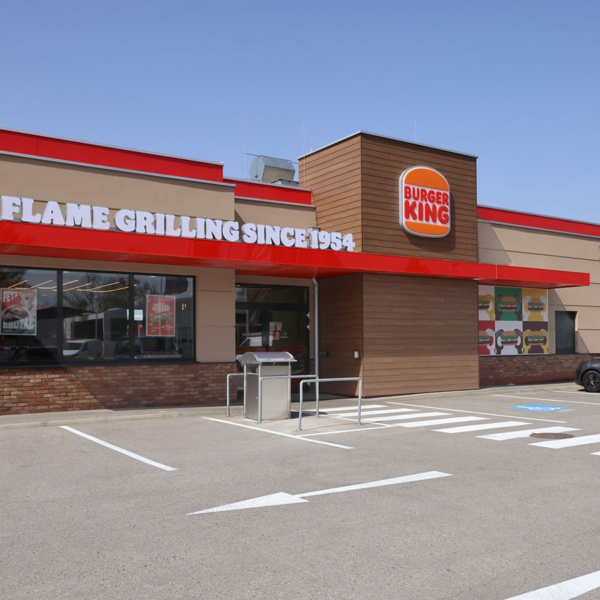 Die Vorderseite eines Burger King Restaurants mit einem roten Vordach und einem Grillzeichen.