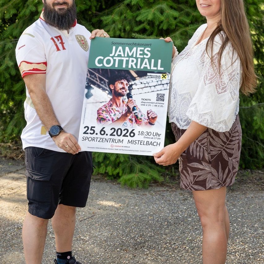 Ein Mann und eine Frau halten ein Plakat für ein Sommerkonzert von James Cottriall am 25. Juni 2026 um 18:30 Uhr im Sportzentrum Mistelbach.