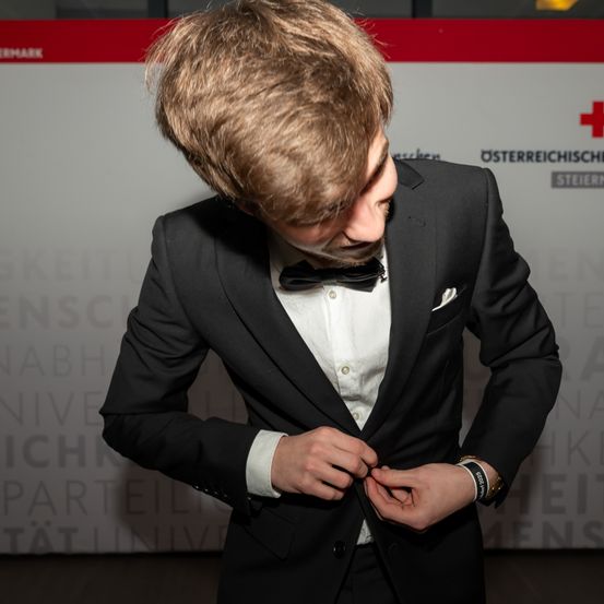 Bild enthält, Logo, Formal Wear, Suit, Adult, Male, Man, Person, Coat, Symbol, Tie