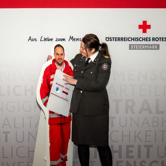 Bild enthält, Logo, Symbol, Adult, Male, Man, Person, First Aid, Red Cross, Suit, Face