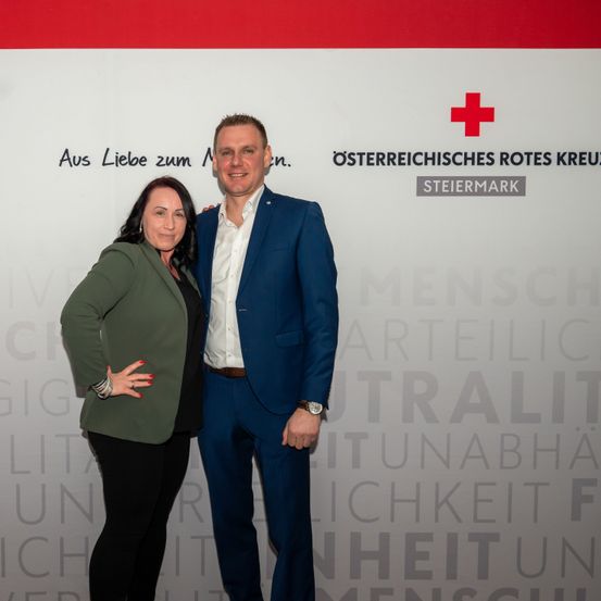 Bild enthält, Logo, Adult, Female, Person, Woman, Symbol, Male, Man, Coat, First Aid