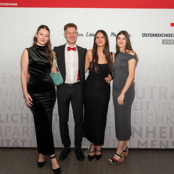 Bild enthält, Adult, Female, Person, Woman, Logo, Formal Wear, Suit, Groupshot, Shoe, Dress