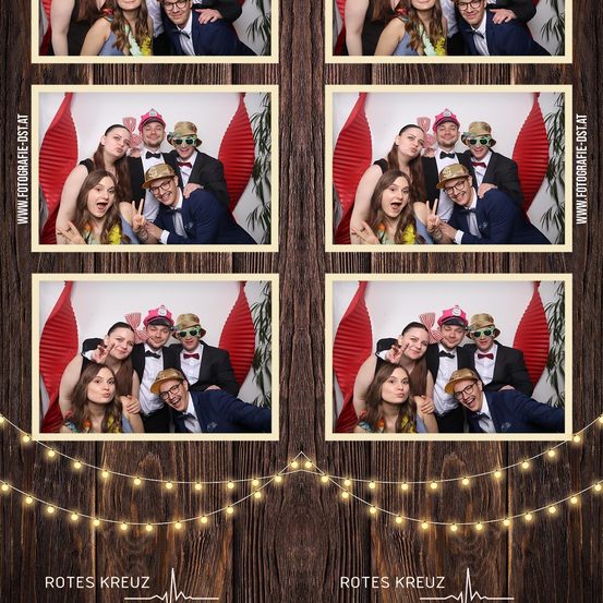 Vier Fotobox-Bilder einer Gruppe von Menschen in Anzügen und Hüten mit roten Dekorationen im Hintergrund. Die Fotos haben einen goldenen Rand und 'Rotes Kreuz' Wasserzeichen.