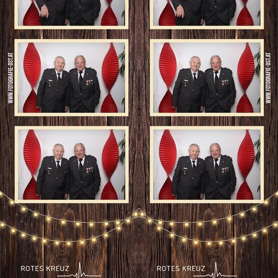Vier Fotos von vier älteren Männern in Militäruniformen vor einem roten Hintergrund. Die Fotos sind in einer Collage auf einem hölzernen Hintergrund angeordnet. Es gibt rote Herzformen und Lichter.