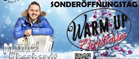 Ein Plakat kündigt eine Sondereröffnung für eine Weihnachtsaufführung an. Ein Mann in einem blauen Mantel spielt Akkordeon, lächelt, mit einem Weihnachtsbaum und QR-Code sichtbar.