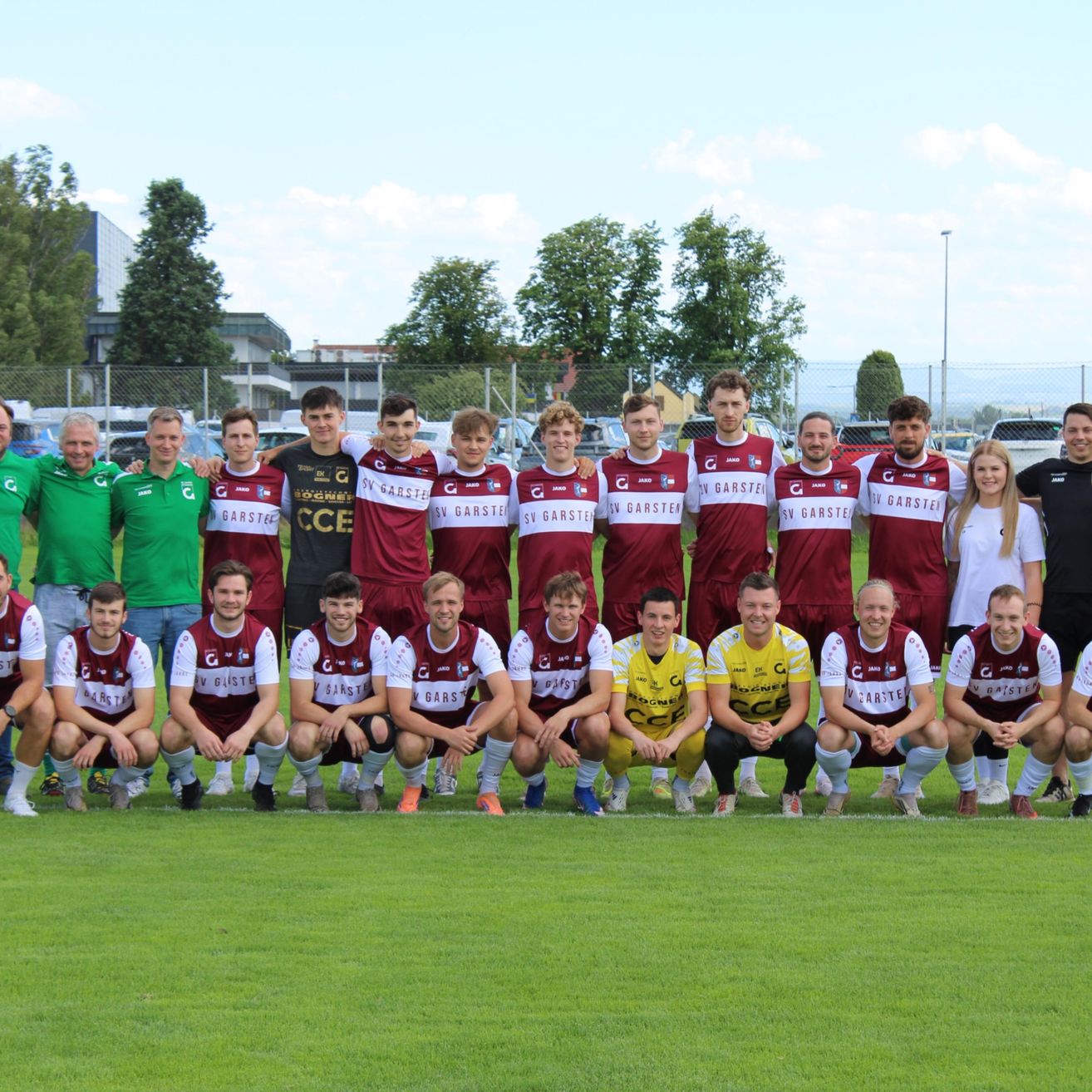 Eine Fußballmannschaft posiert für ein Mannschaftsfoto auf dem Feld, trägt rot-weiße Trikots mit 'Garstei' auf der Vorderseite.