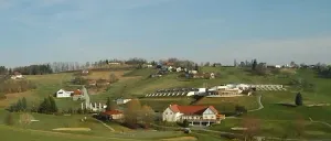 Eine Luftaufnahme eines Golfplatzes mit Häusern und Bäumen. Die Häuser befinden sich auf der rechten Seite, und im Vordergrund befinden sich Golflöcher.