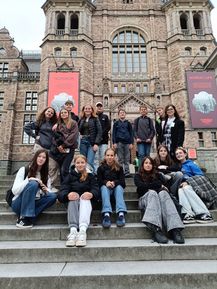Eine Gruppe von Schülern posiert für ein Foto vor einem Gebäude mit Schildern 'Nordic Life'.