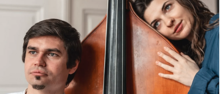 Ein Mann und eine Frau stehen neben einem großen Kontrabass, der Mann sieht ernst aus und die Frau lächelt mit der Hand auf dem Bass.