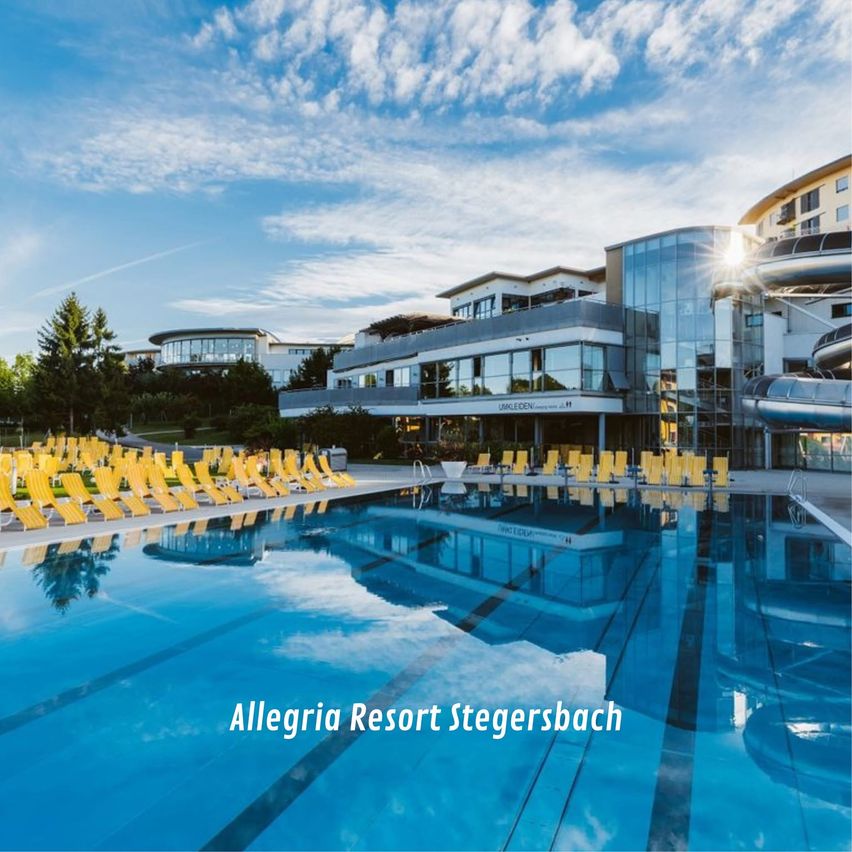 Ein großer Pool mit vielen gelben Liegestühlen, neben einem Gebäude mit Glaswänden und einer Rutsche auf der rechten Seite.