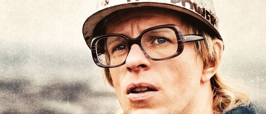 Ein Mann mit Brille und einem Helm mit den Zahlen 14 und 17 sieht ernst aus. Das Wort Gundermann steht auf dem Poster.