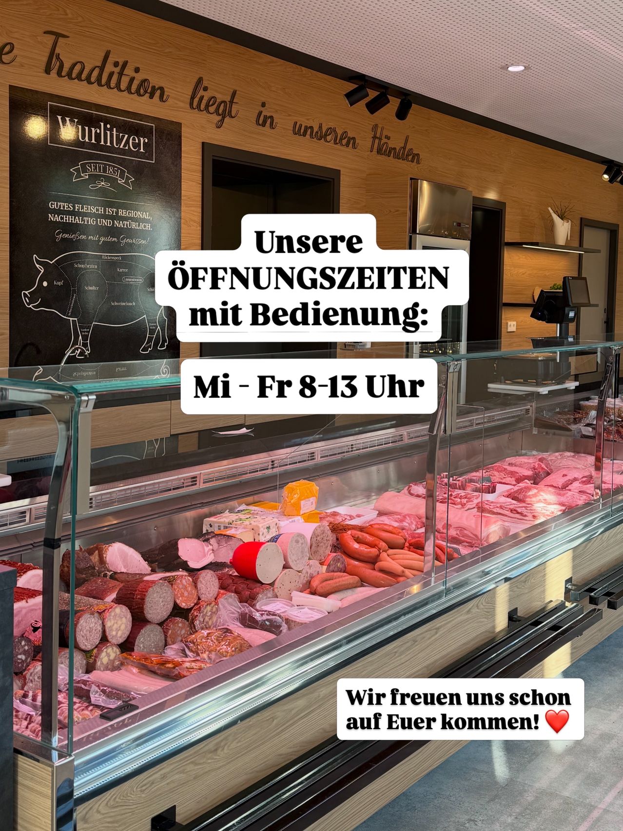 Ein Metzgerladen mit einer Vitrine voller Fleisch. Ein Kreidetafel sagt 'Wurzlitzer' mit einem Schweinezeichnung und Text. Die Öffnungszeiten sind Montag bis Freitag, 8-13 Uhr.