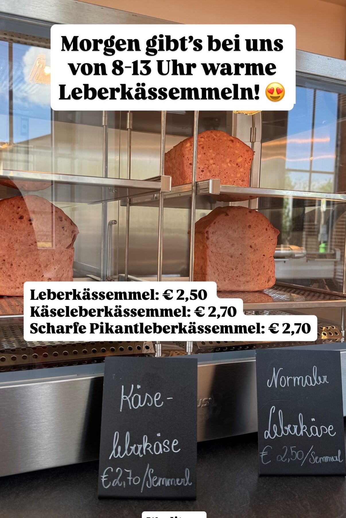 Ein Glasdisplay mit Brot und Textbeschriftungen. Die Preise für verschiedene Brotsorten sind aufgeführt.
