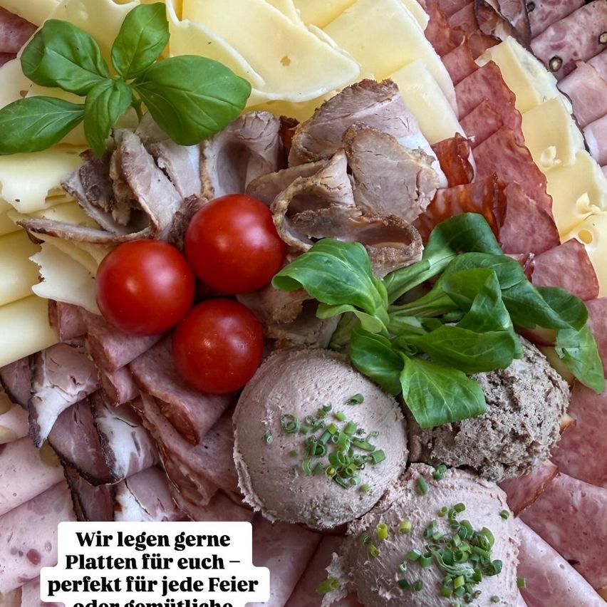 A platter of cured meats, cheeses, and various toppings including tomatoes and basil leaves. The text reads, 'We like to lay plates for you - perfect for any celebration or family.'