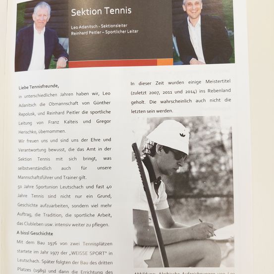 Eine Seite aus dem Geschichtsbuch eines Sportvereins, mit einem Foto eines Mannes in einer weißen Kappe und Sonnenbrille, der einen Stift hält, und Text auf Deutsch über die Geschichte der Tennisabteilung.