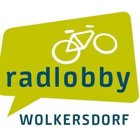 Die grüne Sprechblase enthält ein weißes Fahrrad-Symbol mit dem Wort 'radlobby' in blauer Schrift oben und 'WOLKERSDORF' in schwarzer Schrift unten.